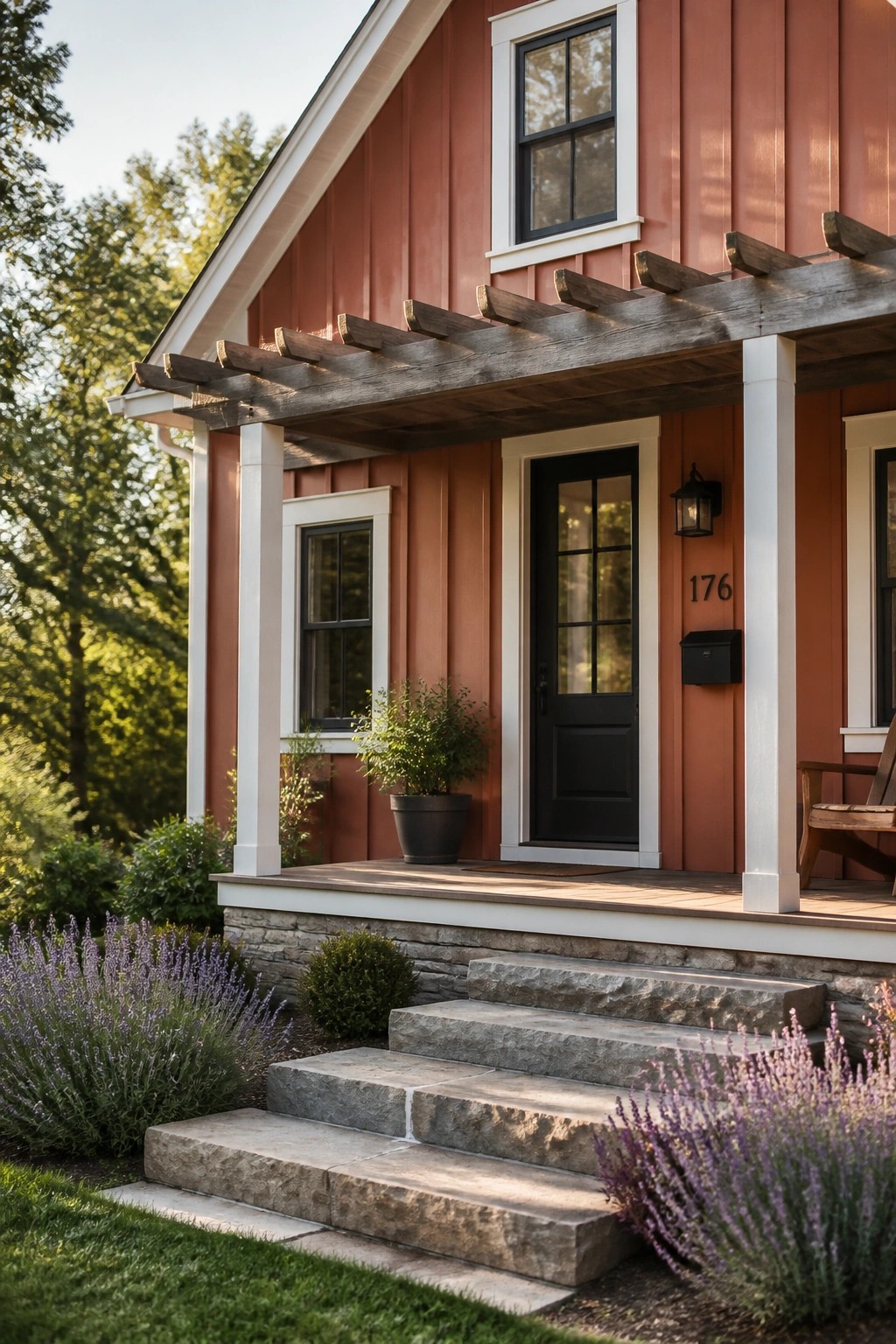 A modern farmhouse exterior with warm terracotta red siding and white trim.