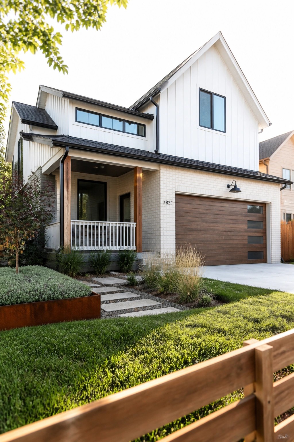 Modern farmhouse exterior featuring white vertical siding, light brick on the lower facade, a brown garage door, and a covered porch with white railing.