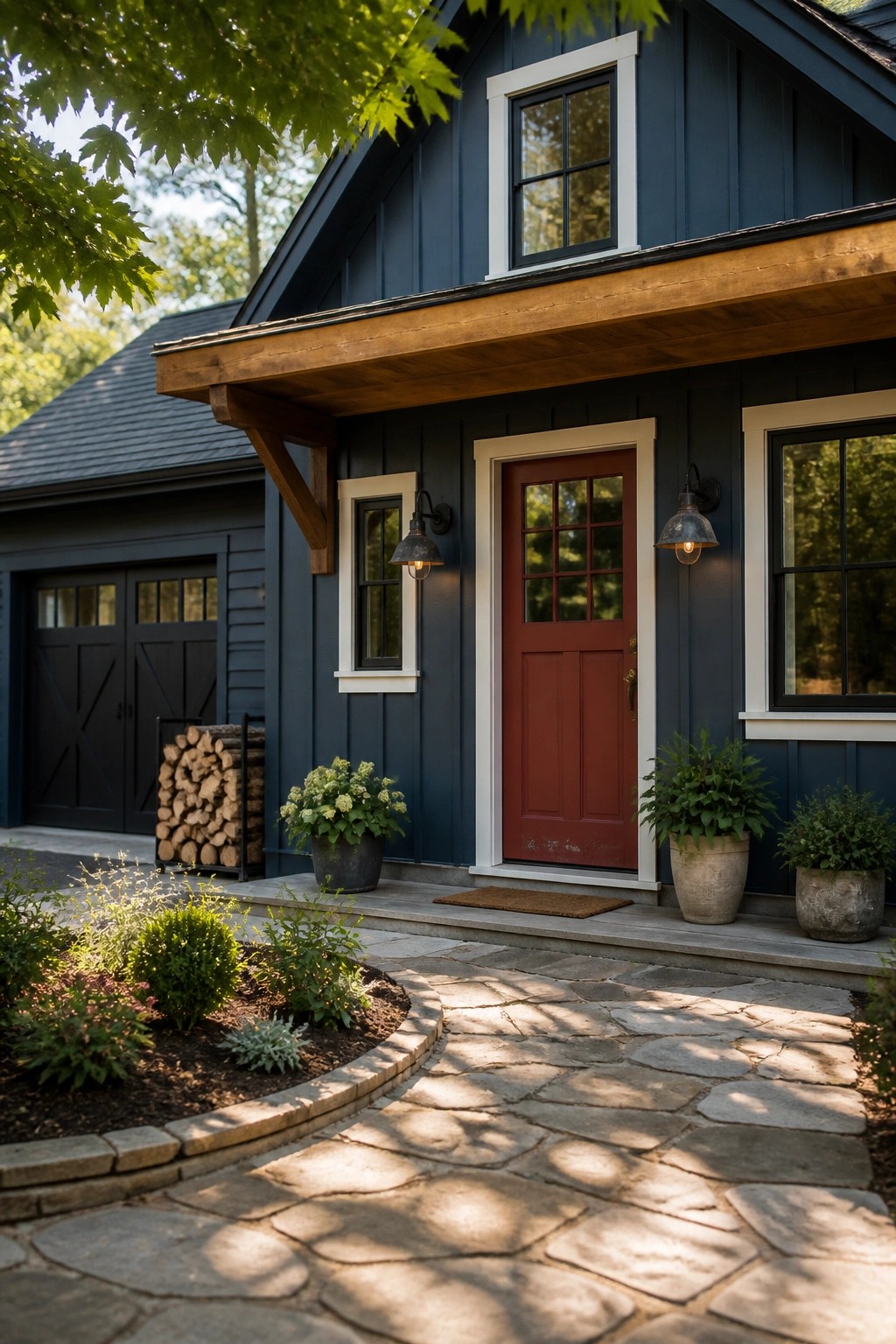 A dark blue farmhouse exterior with white trim, a red front door, stone pathway, and potted plants along the entry.