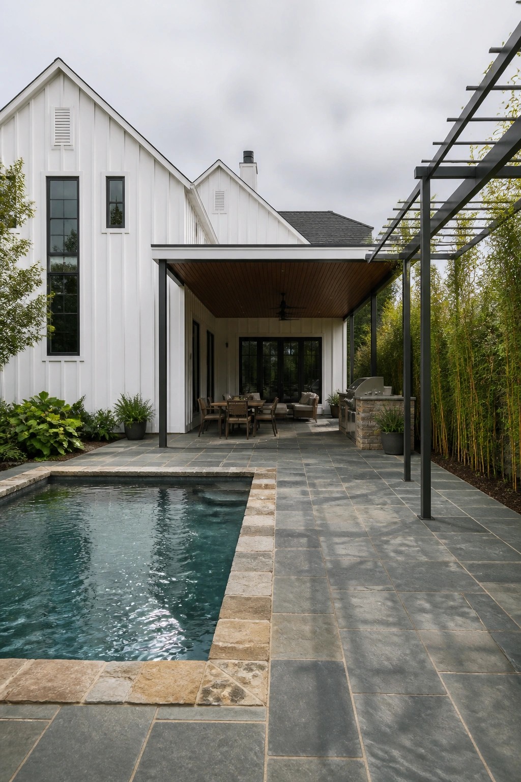 Modern white house with pool, stone patio, outdoor dining and grill area