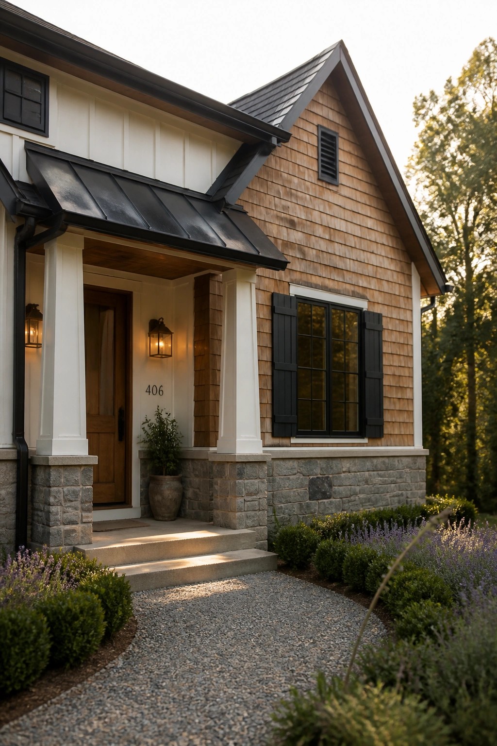 A two-story farmhouse exterior featuring white vertical siding on the left, cedar shake shingles on the right and gable, a stone foundation, black shutters, a covered porch with columns, and a gravel walkway.