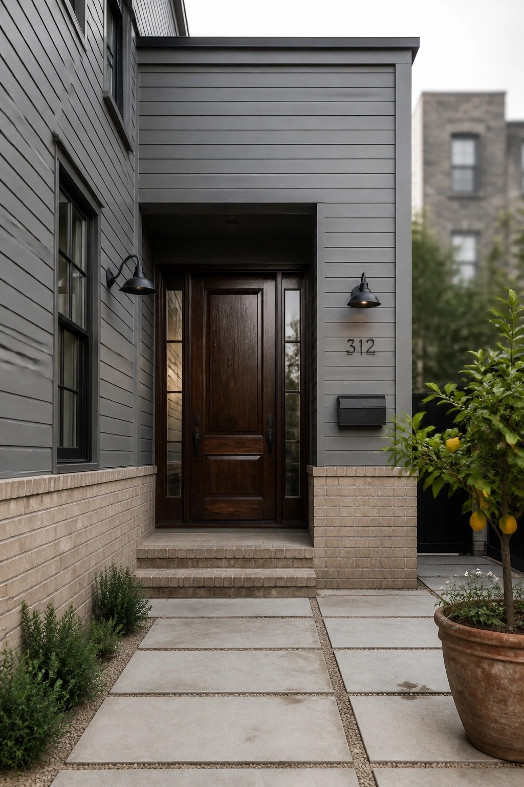 Gray house entrance with dark wood door, concrete steps, potted lemon tree, and house number 312.