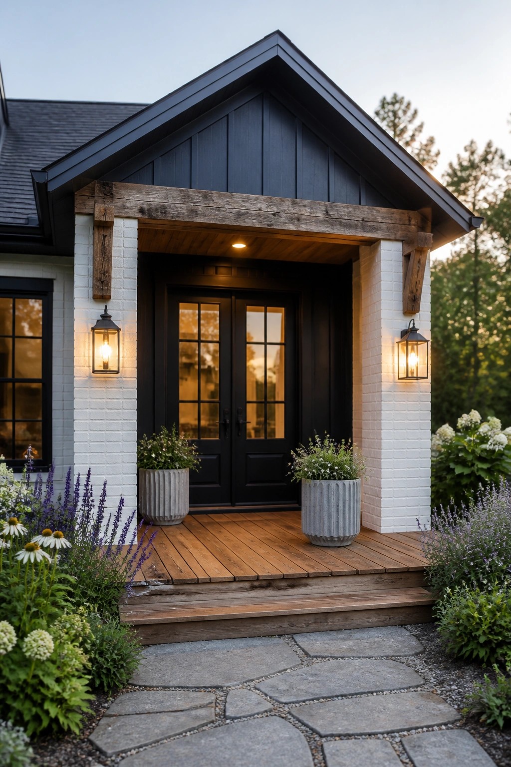 Front view of a farmhouse entry with white brick columns, dark vertical siding, a wooden beam header, black double doors, and a wooden porch.