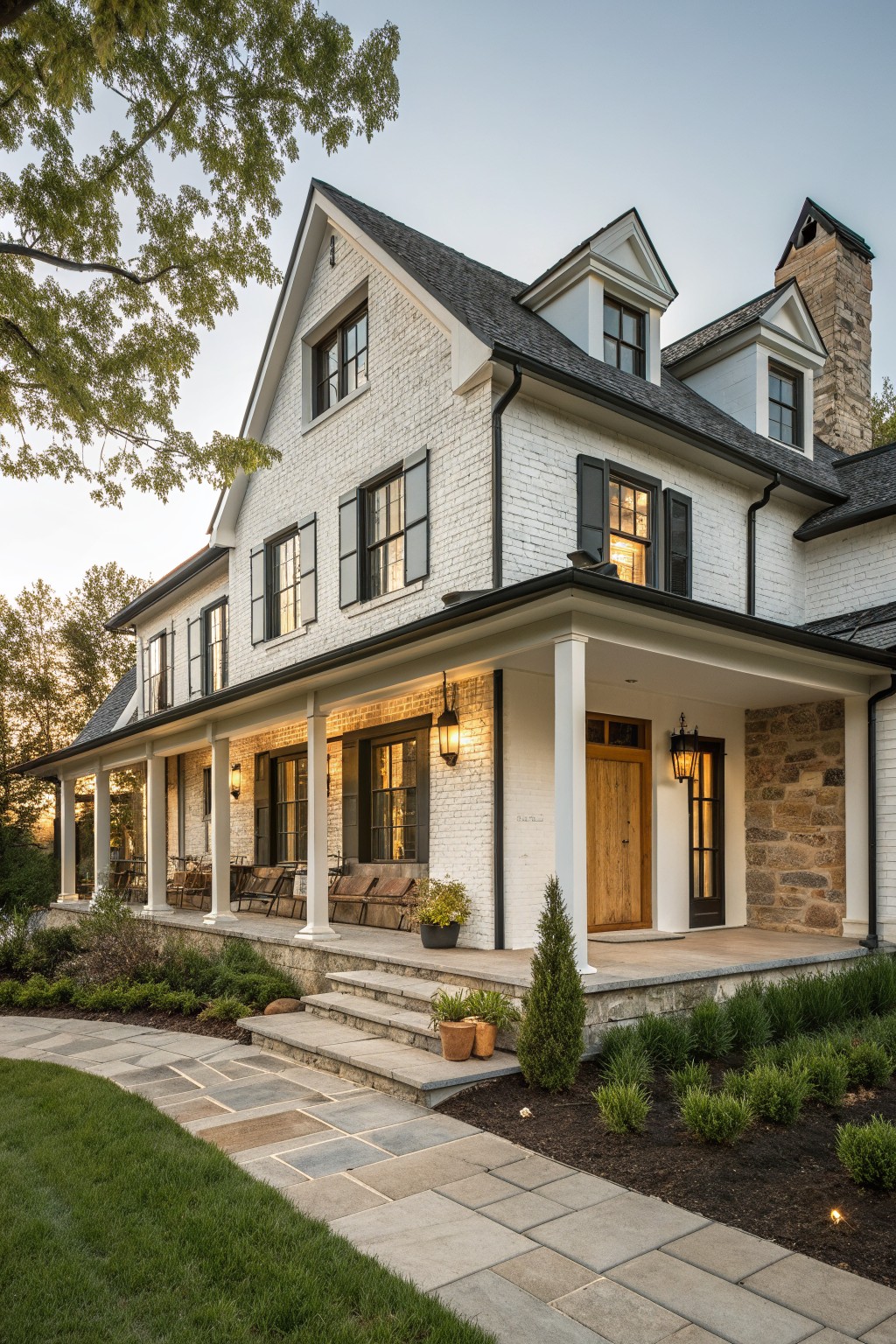 White brick house with black shutters, porch columns, wooden door, and stone chimney