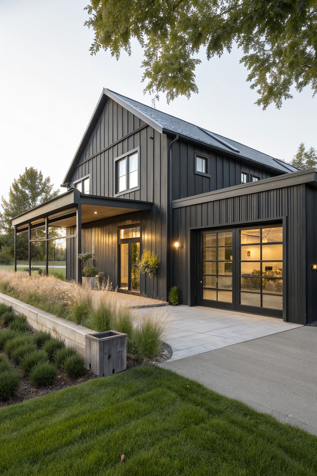 Modern black house with gabled roof, glass doors, and landscaped lawn.