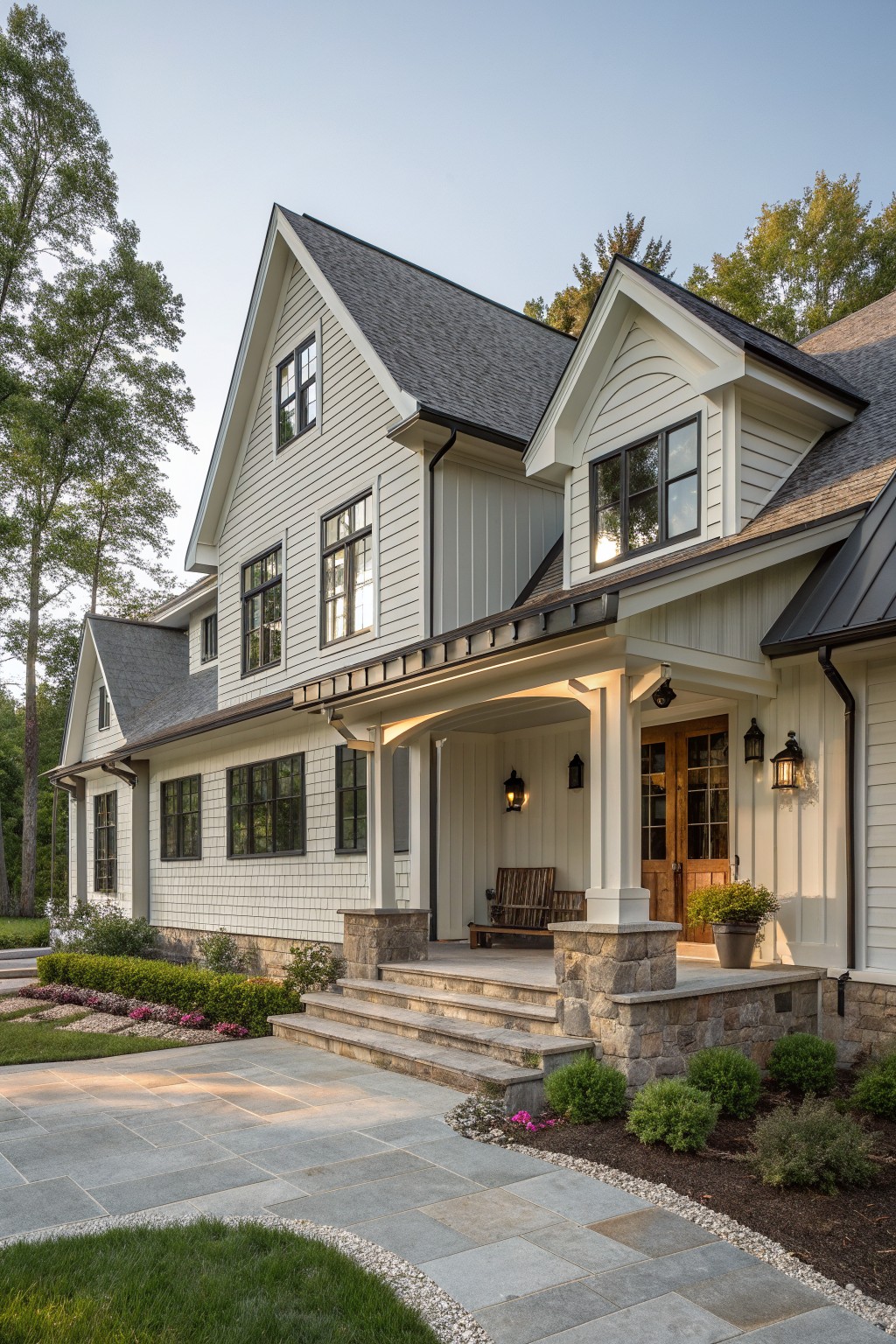Large white two-story house with gray roof, stone porch, and steps.