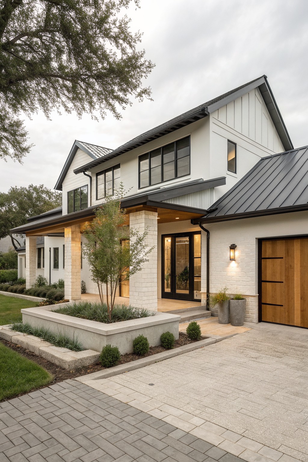 Modern white two-story house with black roof, porch, and paved driveway
