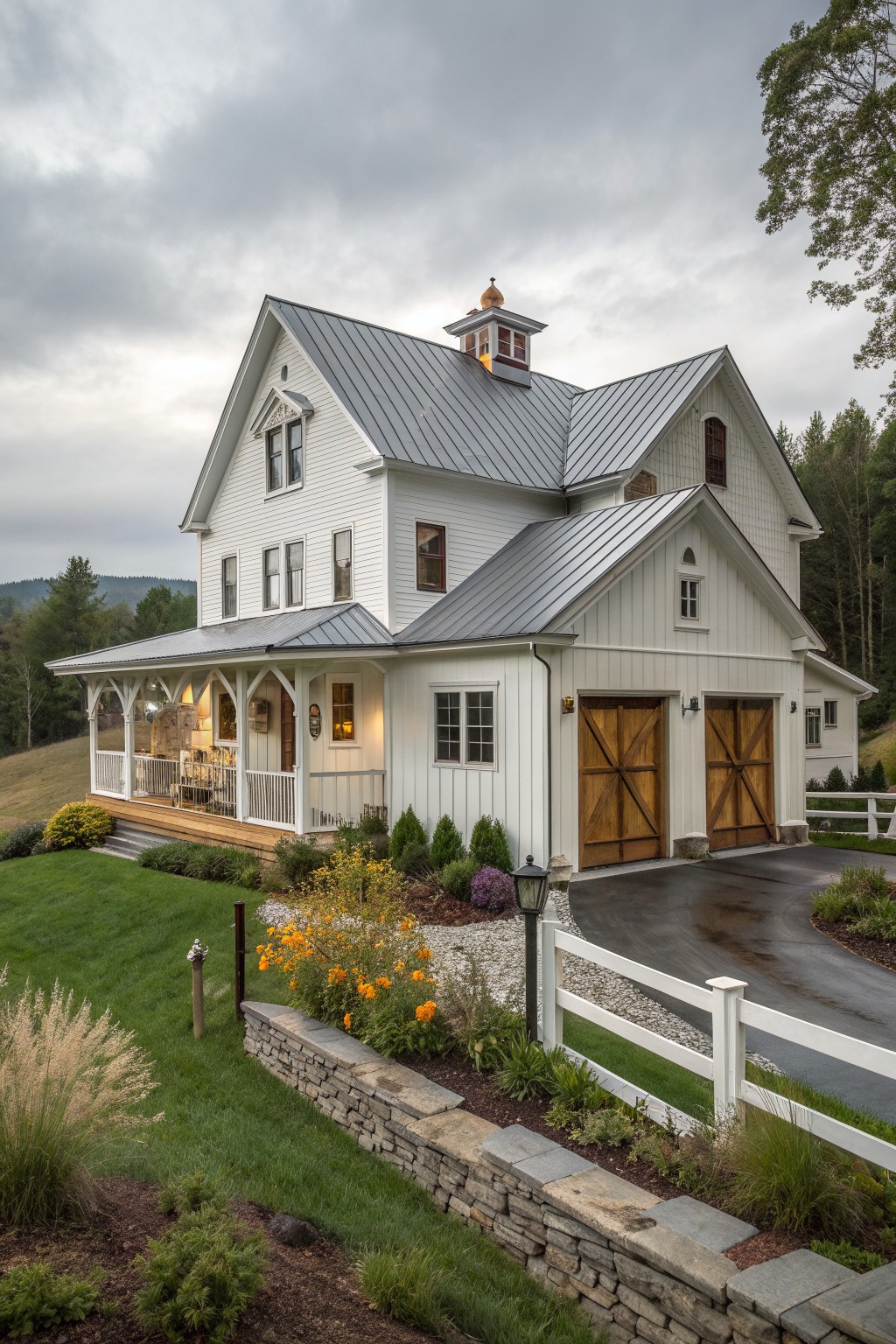 A white two-story farmhouse exterior with metal roofing, wooden barn-style garage doors, a covered porch, and landscaped front yard.