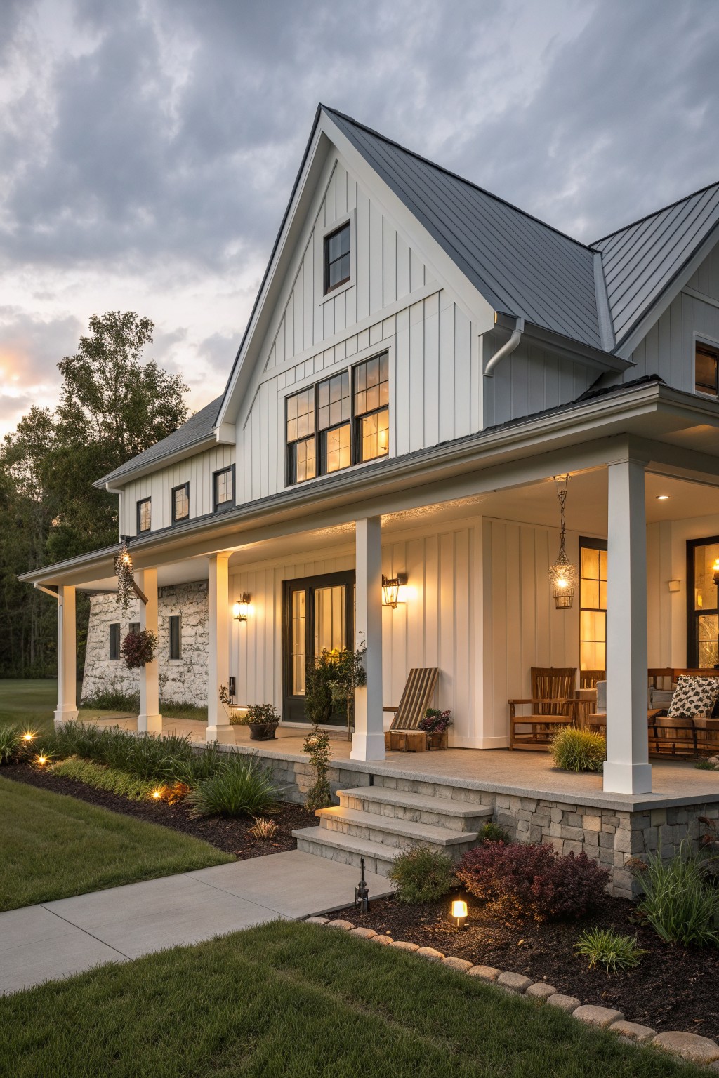 A two-story modern farmhouse with white vertical siding, a dark metal roof, stone accents on the lower walls, and a wide covered porch supported by white columns.