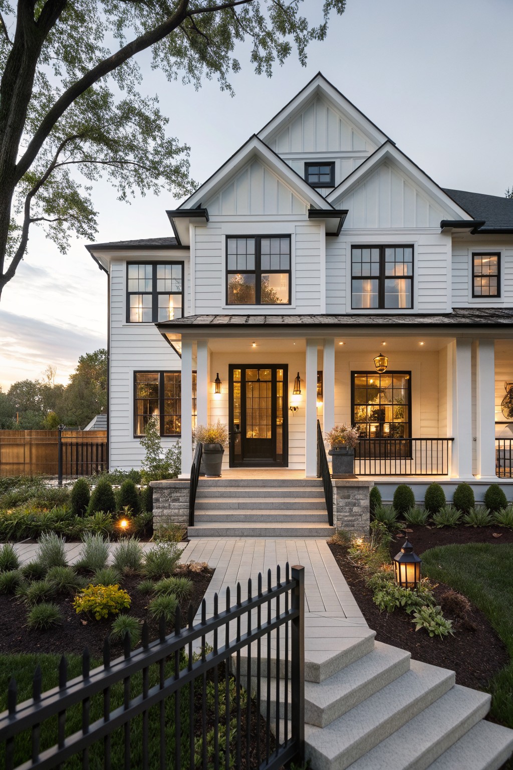 A two-story white farmhouse exterior with black-framed windows, a covered front porch, stone steps, and landscaping along the walkway.