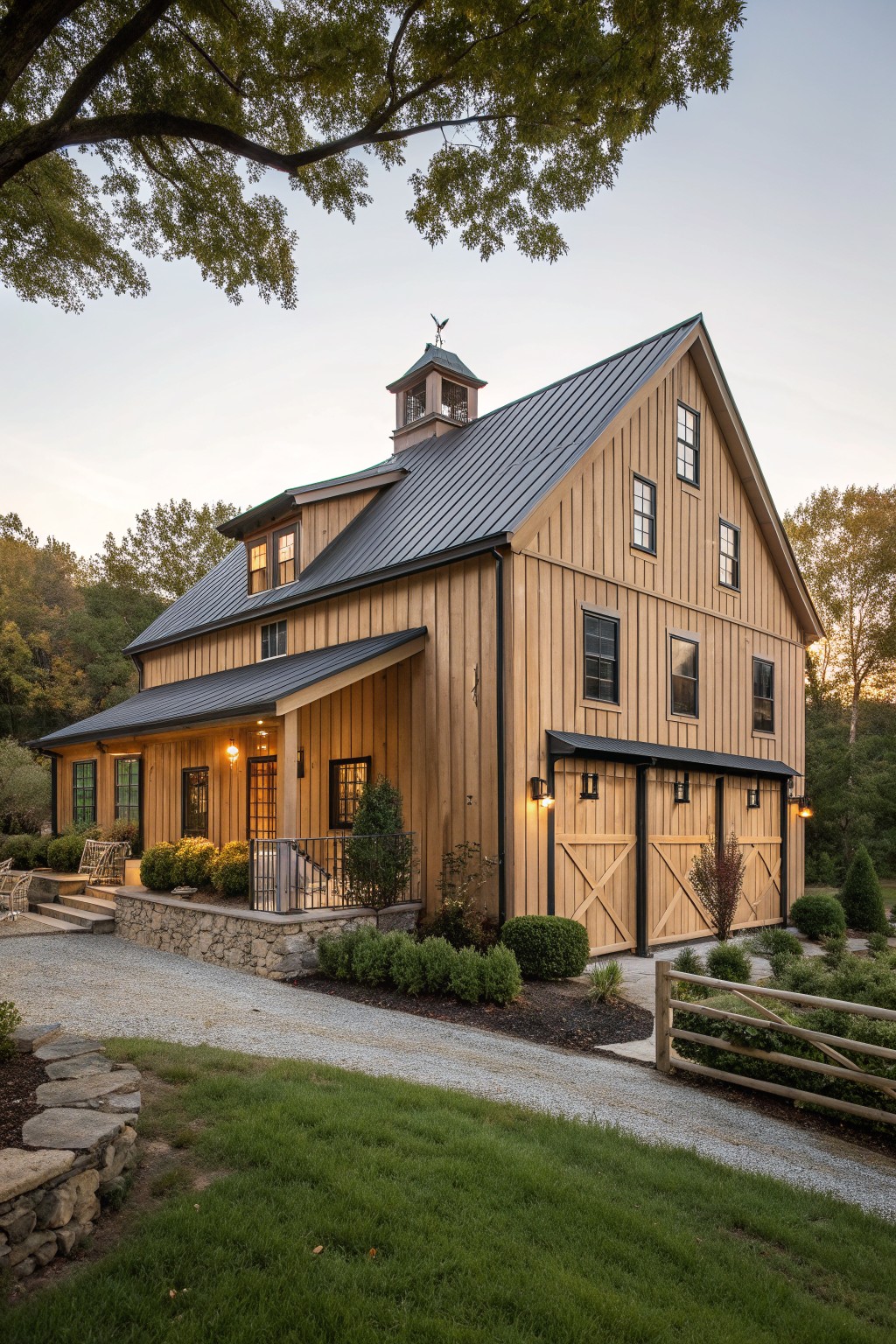 A two-story wooden farmhouse exterior with vertical siding, a dark metal roof, a cupola, and large barn-style doors on the right side.