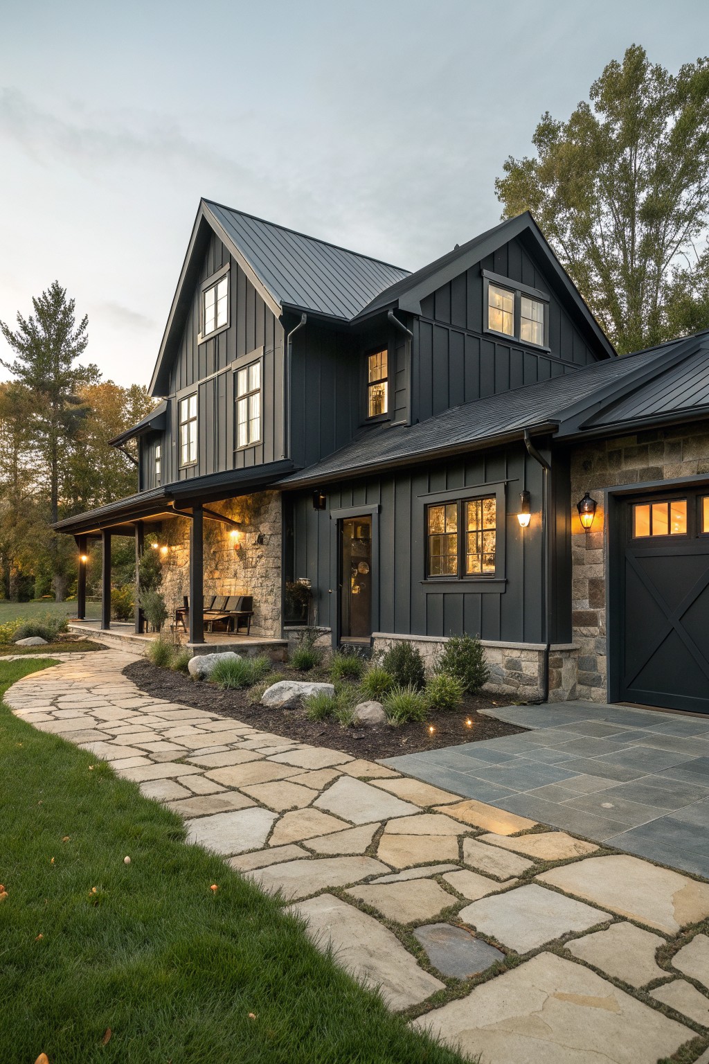 A two-story modern farmhouse with dark vertical siding, a metal roof, stone accents around the base and garage, and a stone pathway in the foreground.
