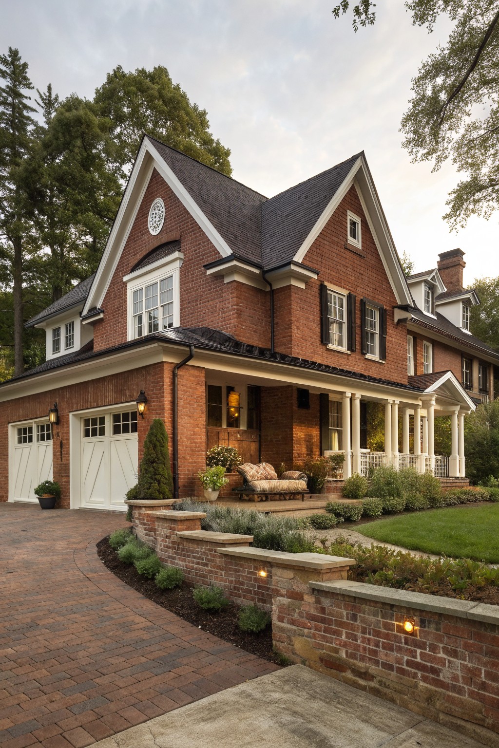 Two-story red brick house with white columns, porch, and paved driveway.