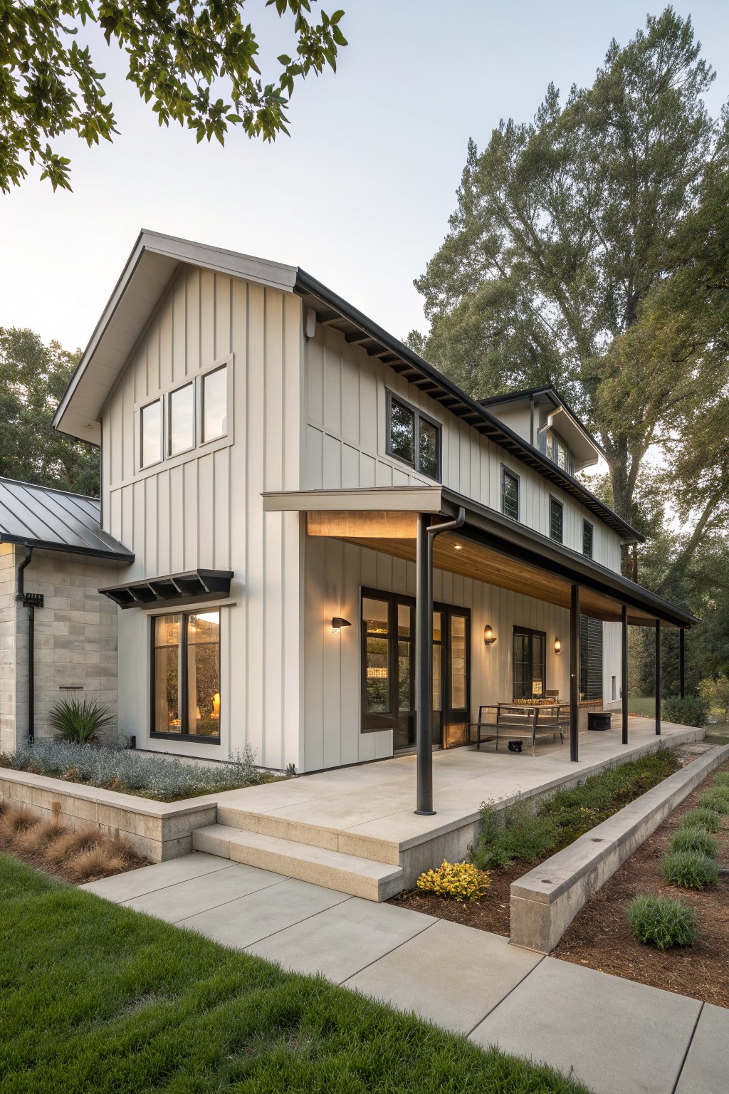 A two-story farmhouse exterior showing vertical white siding, a stone section on the left, a metal roof, and a covered porch with wood ceiling.