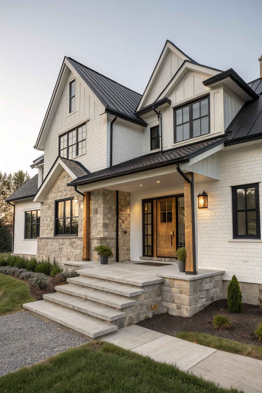 A two-story modern European farmhouse with white brick walls, stone accents at the base, a dark metal roof, and multiple dark-framed windows.