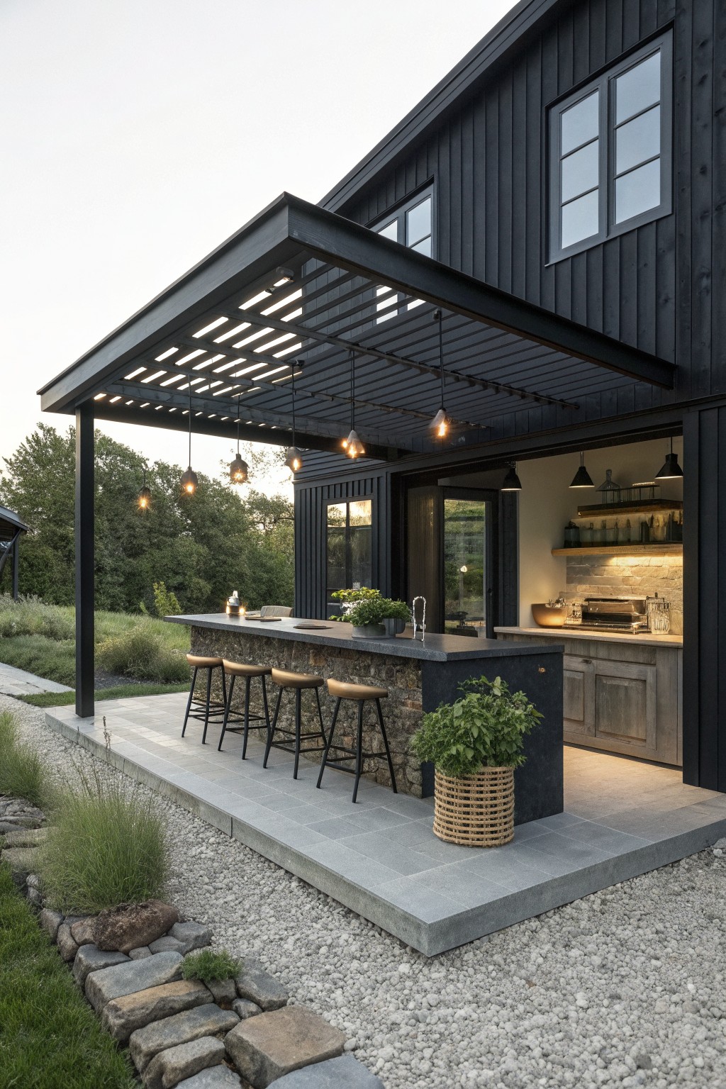 Modern black house with covered stone outdoor kitchen bar, stools, and pendant lights.