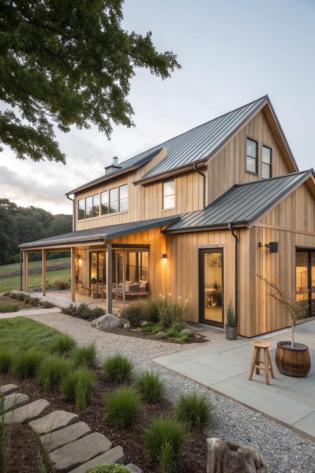 Modern wooden house with metal roof, large windows, patio stool, and garden path.