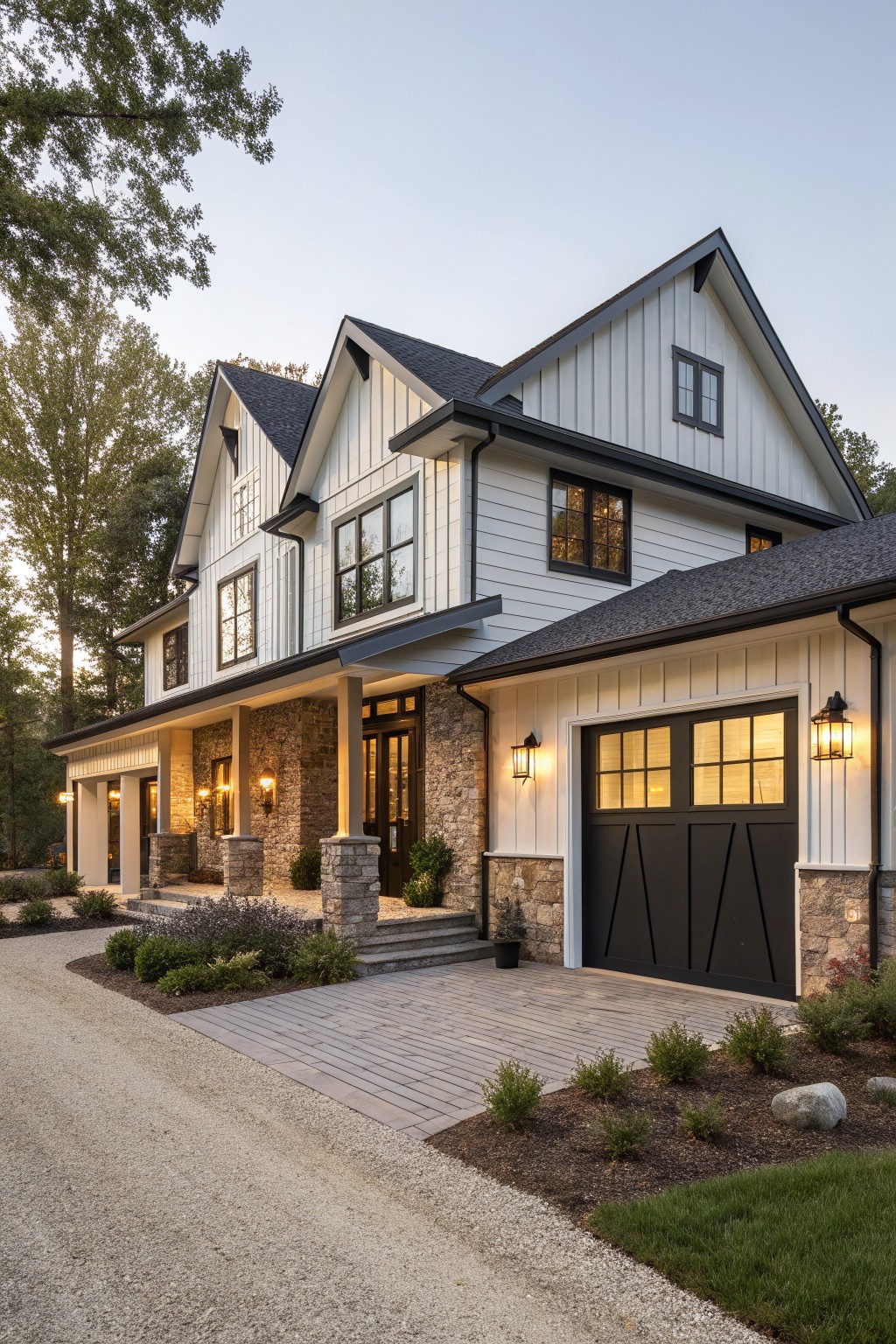 A two-story contemporary farmhouse exterior with white vertical siding, dark trim, stone veneer on the lower walls and columns, a dark front door, and a black garage door.