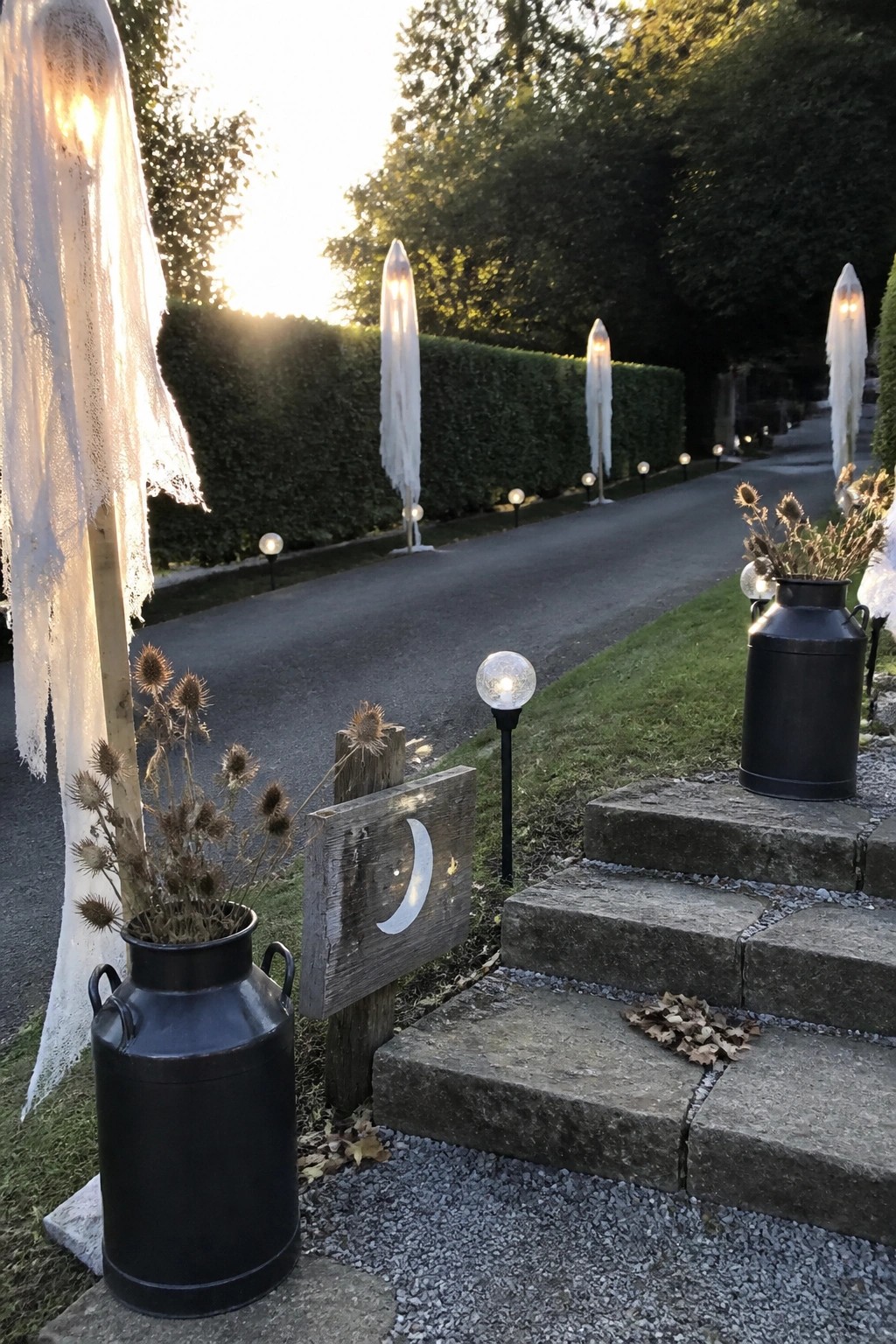 Glowing ghost figures line a twilight garden path with stone steps and milk cans.
