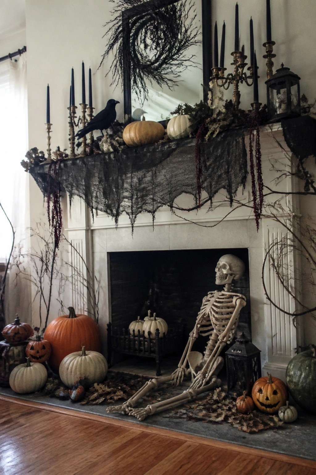 Fireplace with a skeleton posed on the hearth, black candles and a crow on the mantel, and pumpkins arranged around the base.