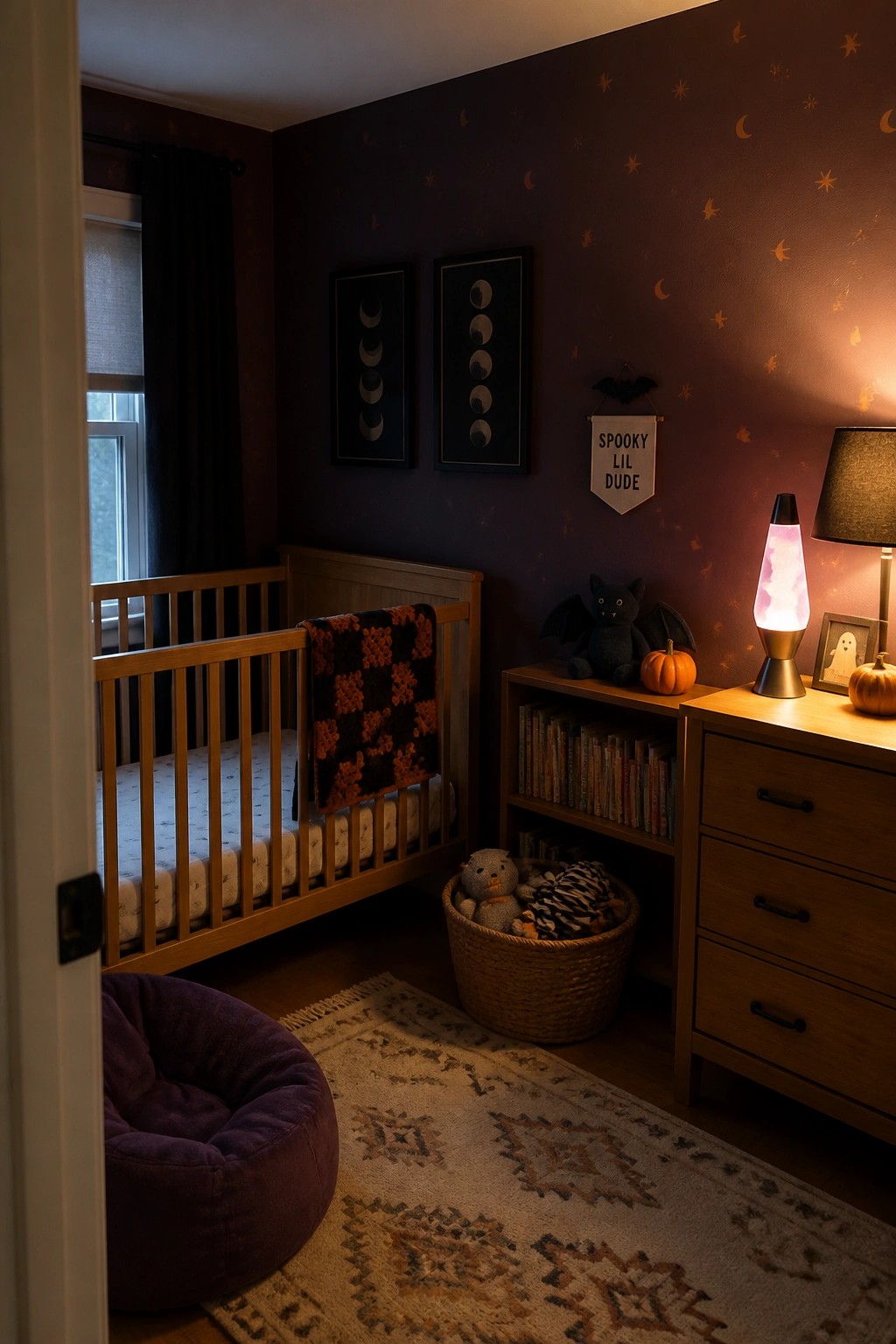 A nursery with dark purple walls decorated with small stars, moons, and bats, a wooden crib, a low bookshelf, and a dresser holding a lit lava lamp.