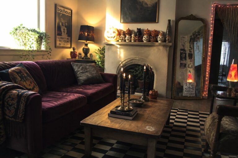 A living room with a purple sofa, wooden coffee table on a black and white checkered rug, string lights along the walls, pumpkins, candles, and a fireplace mantel.