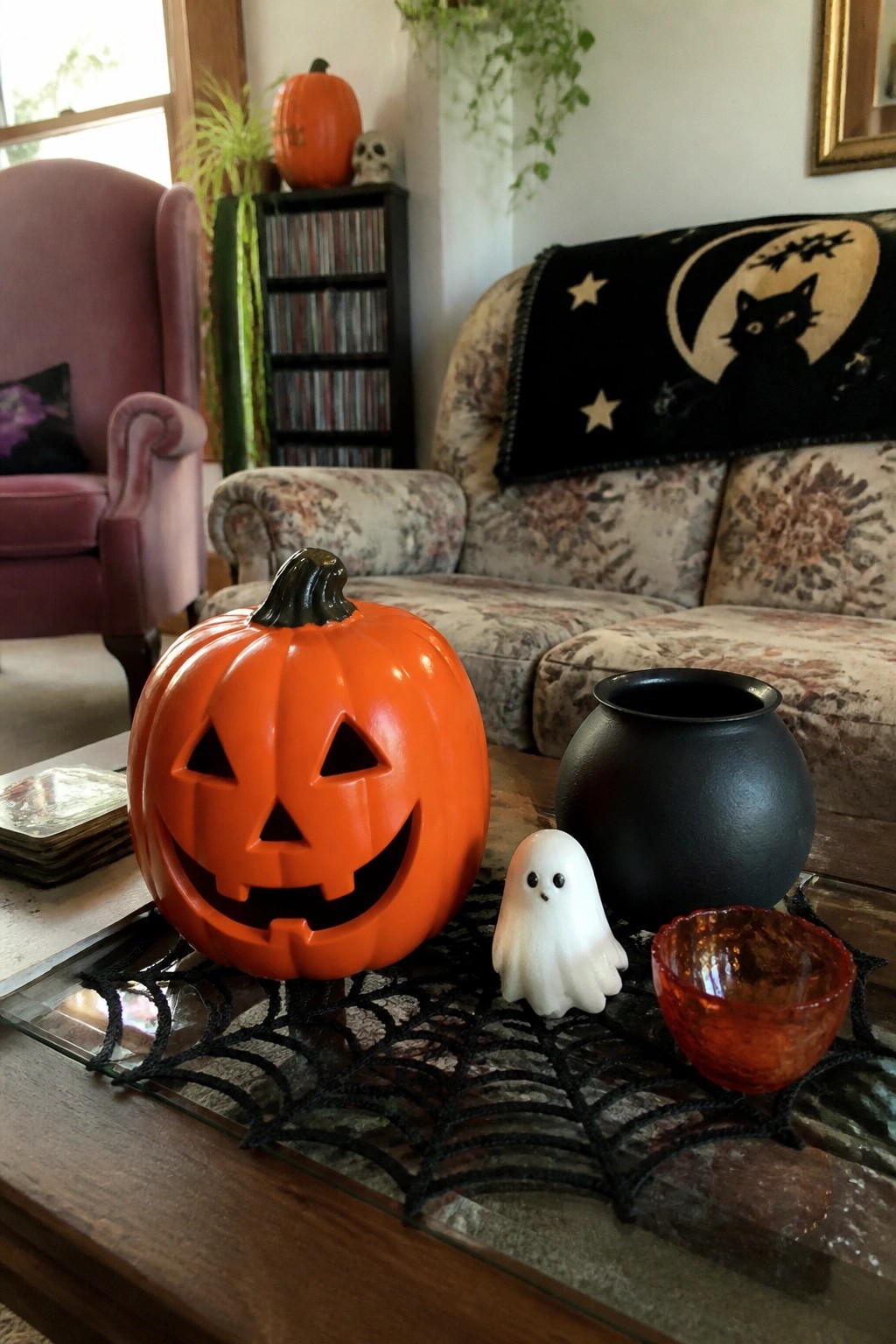 Orange jack-o'-lantern, white ghost, black cauldron and amber bowl on spiderweb mat
