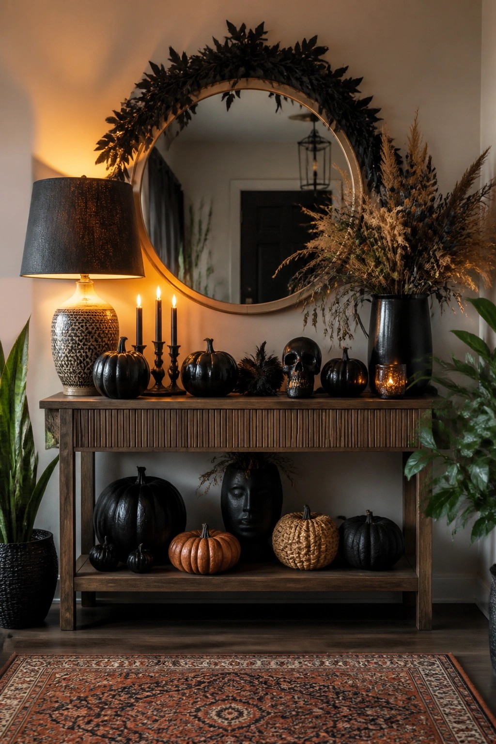 Halloween console table with black pumpkins, skull, candles, and wreath-framed mirror.
