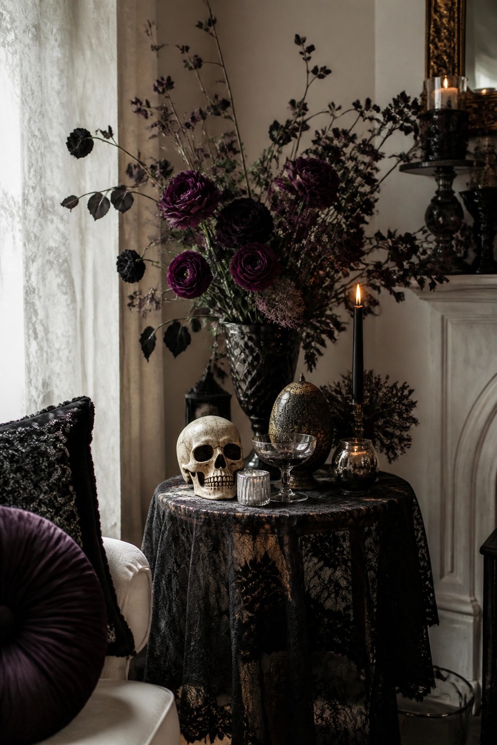 Round table covered in black lace holding a decorative skull, a vase of dark purple flowers, and several lit black candles.